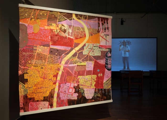 Ida Lawrence, A village and surrounds III (kehidupan baru) 2019 acrylic on unstretched canvas, 160x185cm. (Right) FX Harsono, Writing in the Rain 2011, video installation. Photo Ida Lawrence.JPG